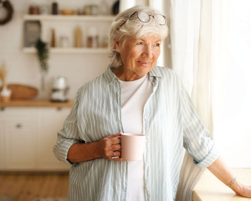 Elderly woman with tea smiling