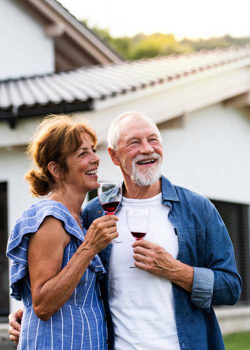 senior couple outside enjoying a glass of red wine