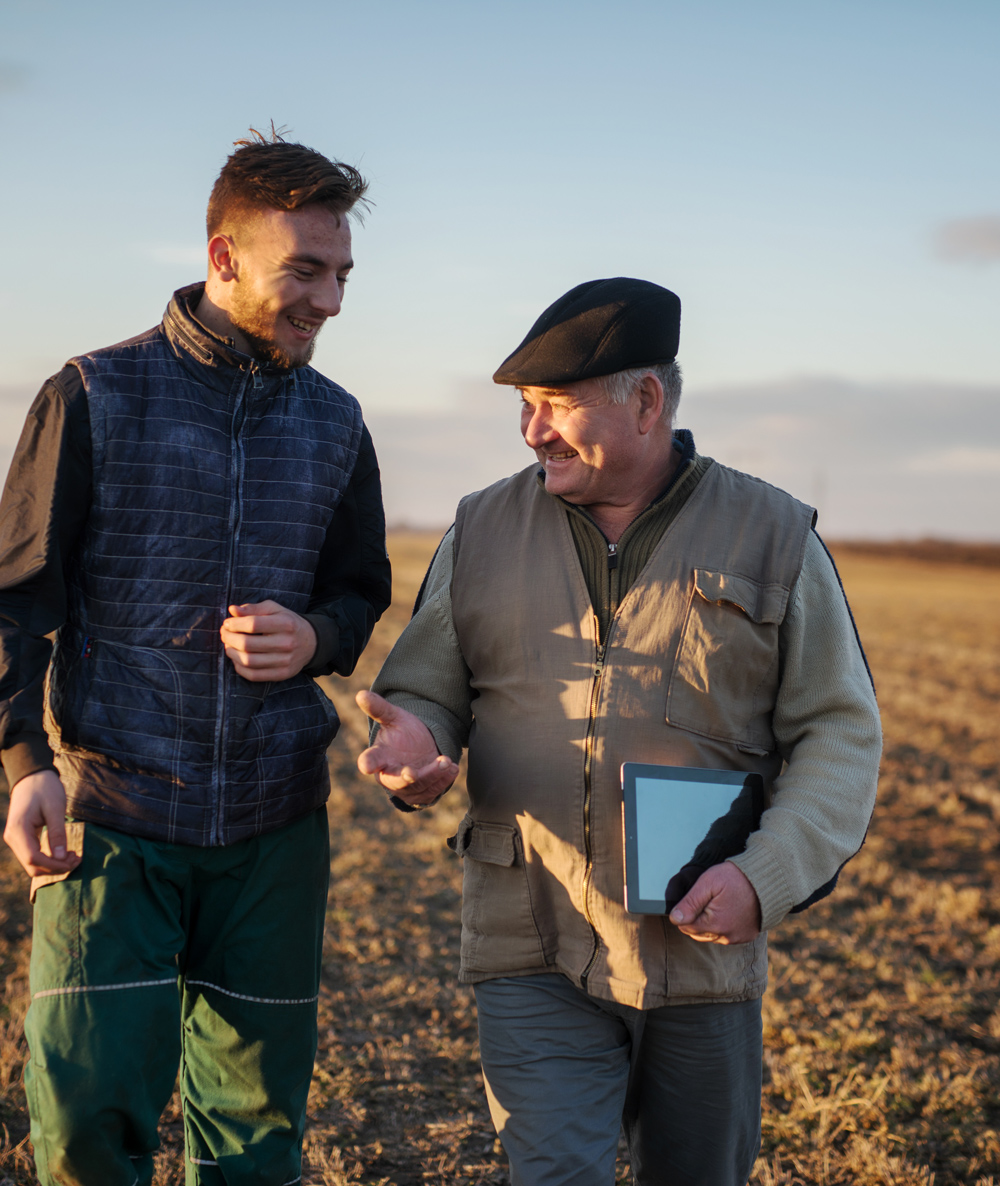 farmer father and son walking through their crop field