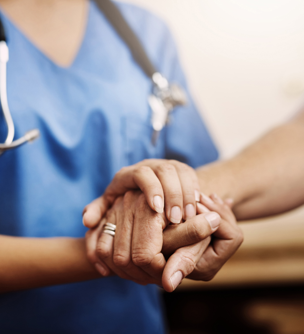 nurse holding patient hand for comfort