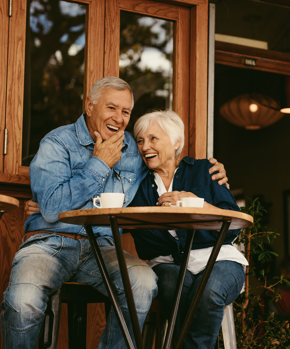 senior couple laughing outside at a coffee shop