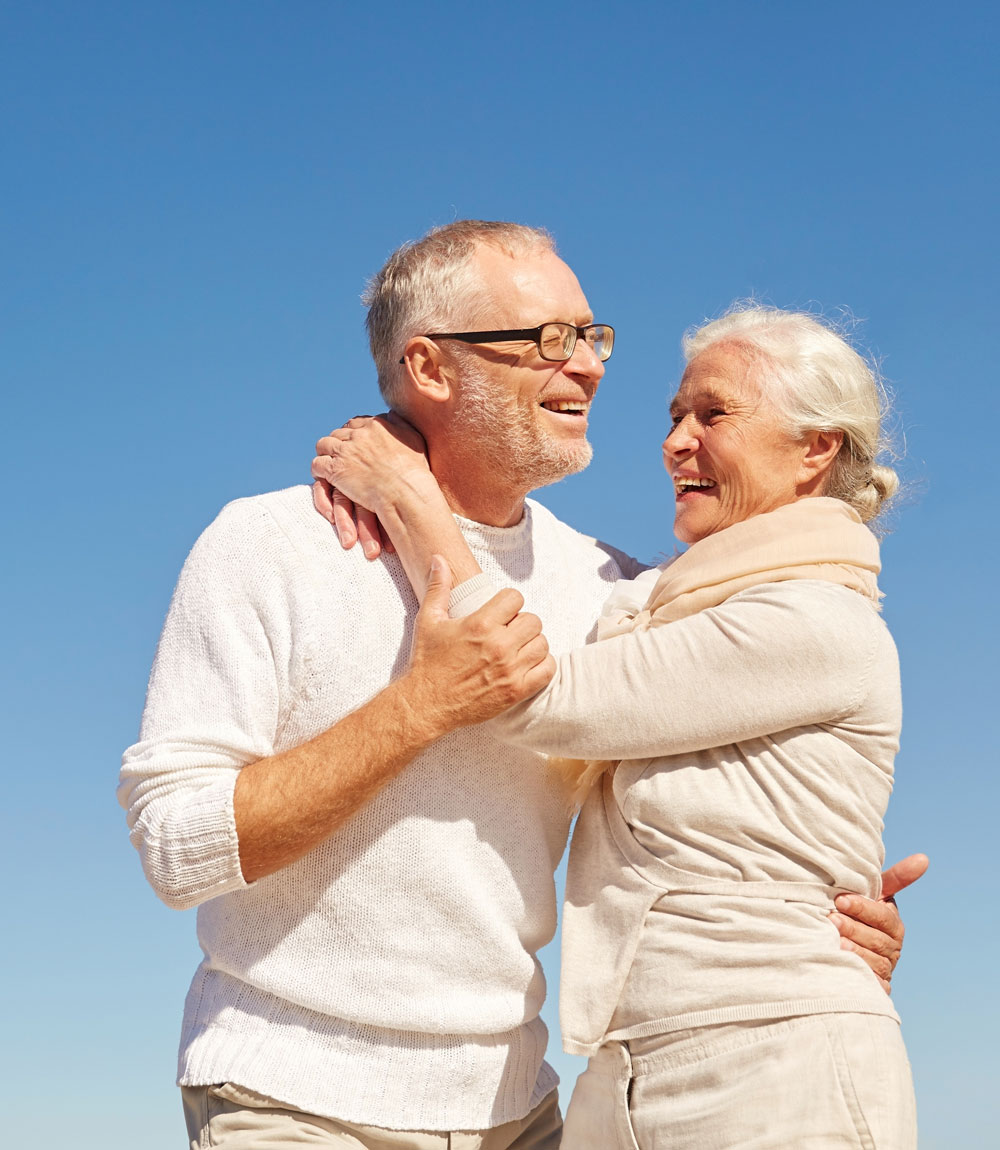 happy senior couple hugging outdoors