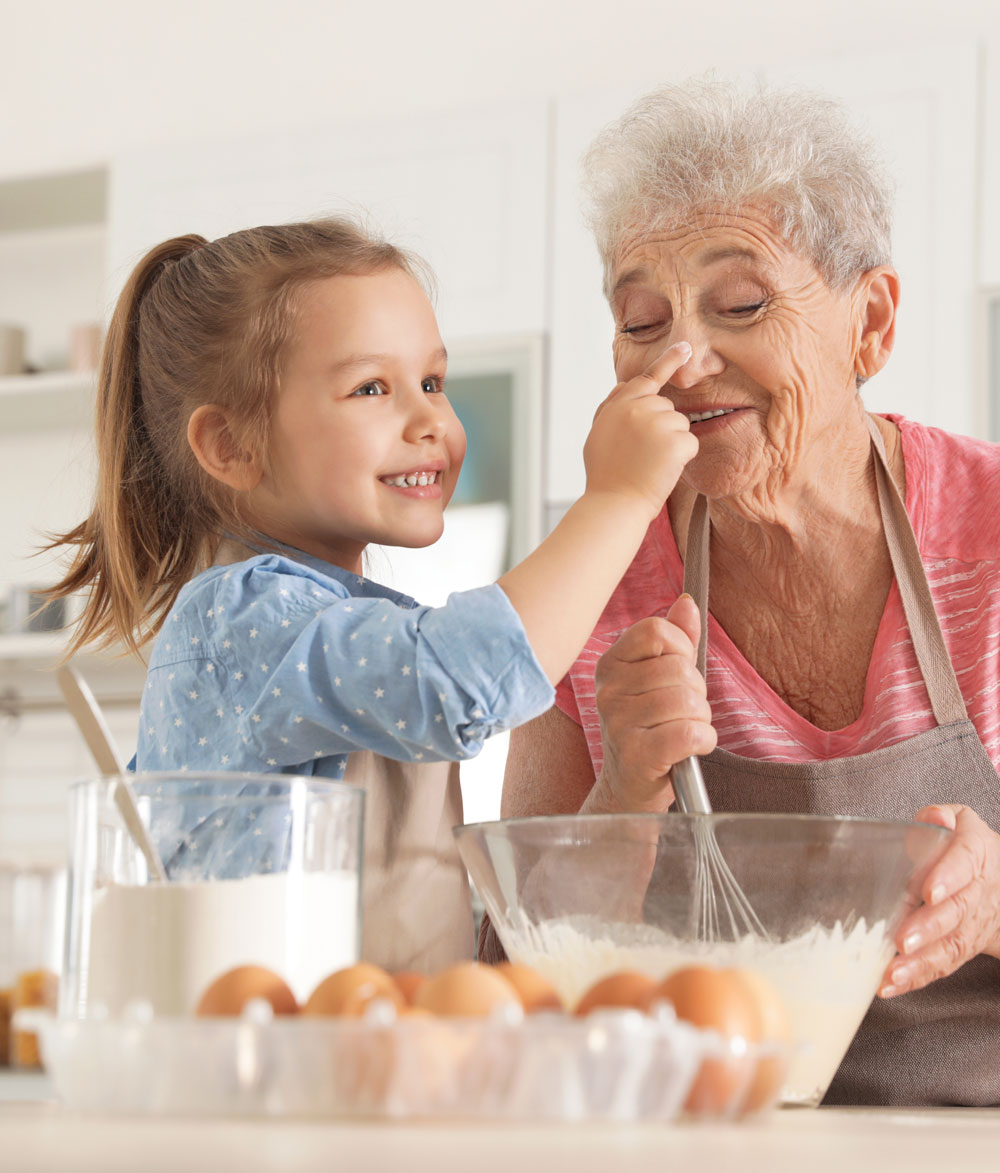 girl and her grandmother cooking in kitchen