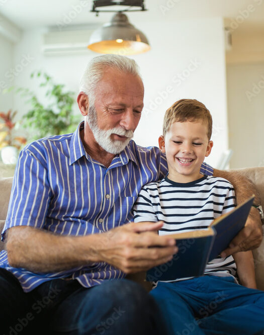 granddaughter sitting on a cupboard while her grandmother teaches her how to pot a plant