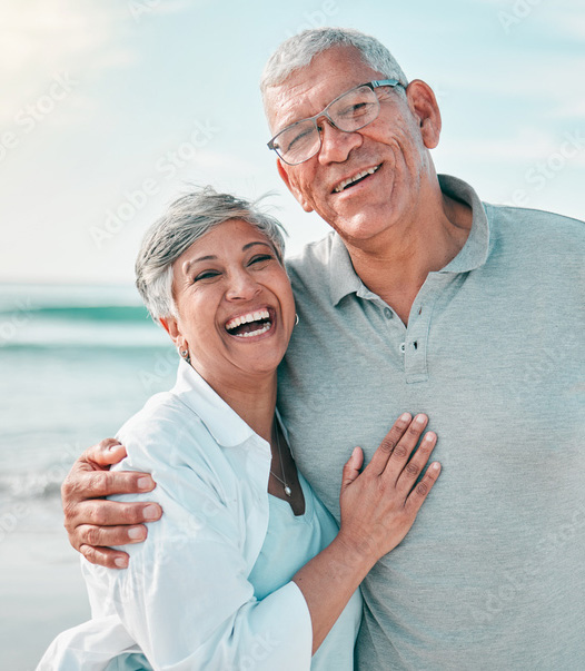 mature couple walking through park carrying yoga mats