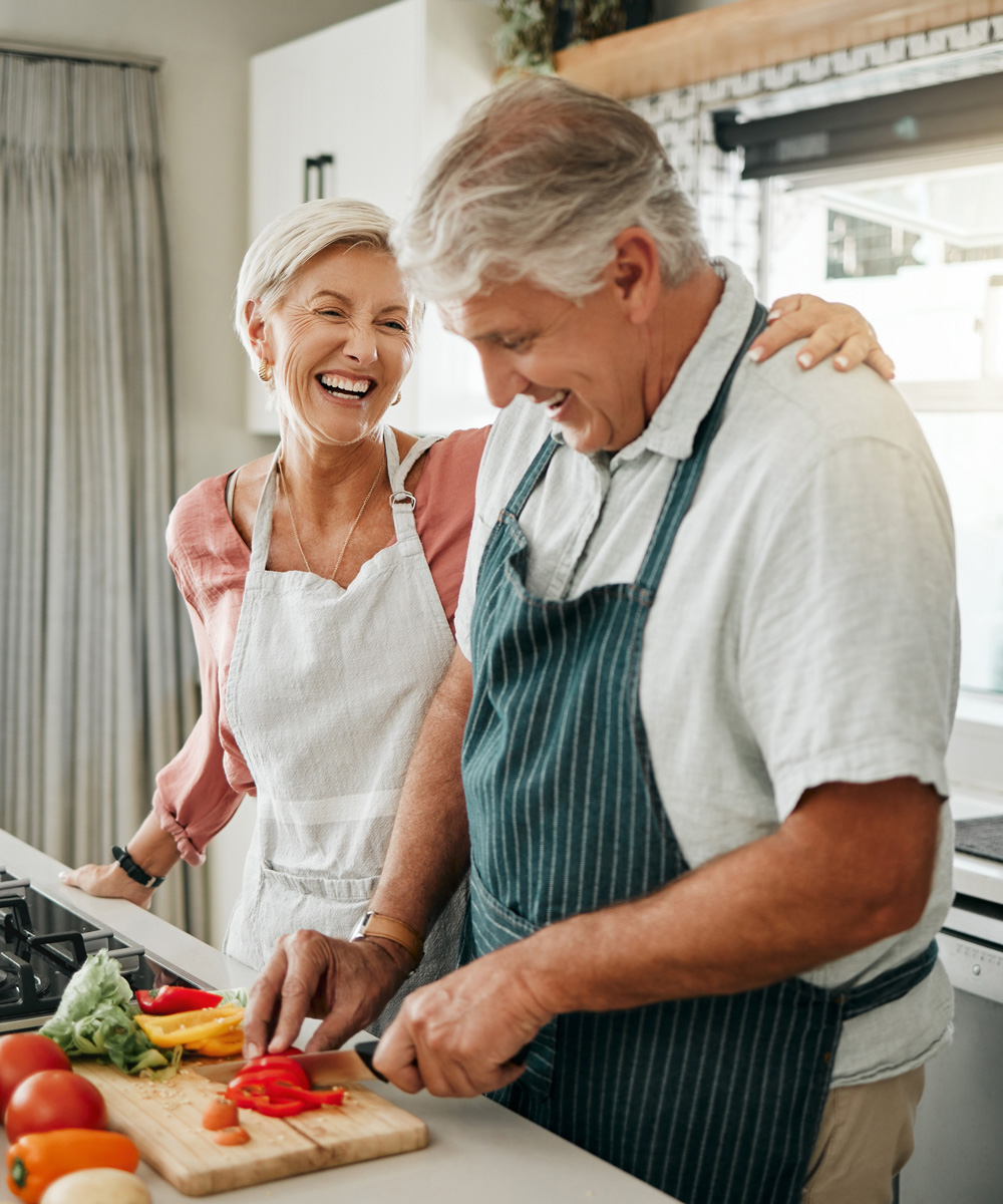 Senior couple, cooking and having fun while preparing dinner