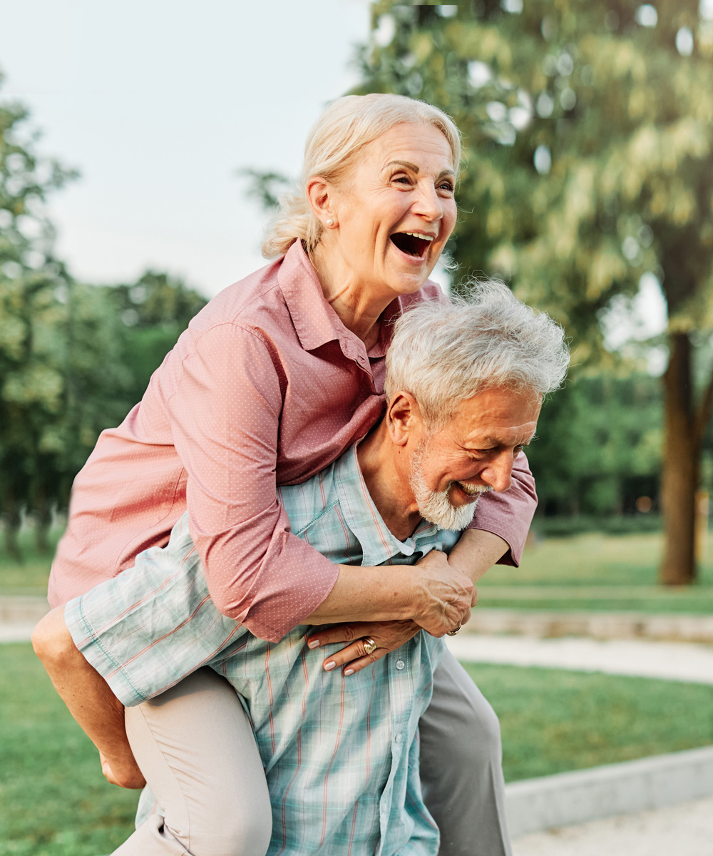 senior couple laughing piggyback