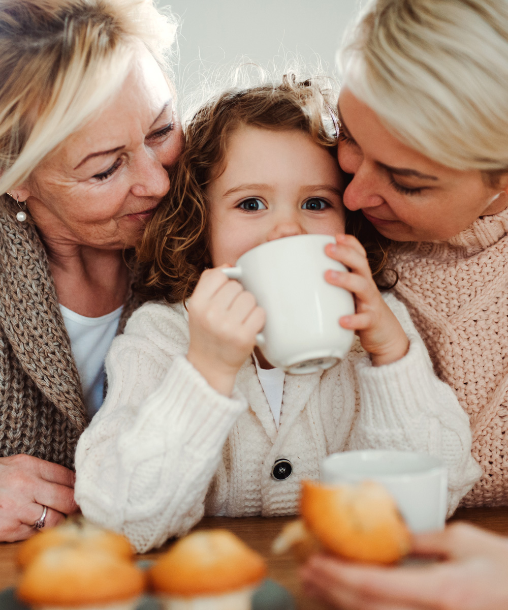 daughter, mother, and grandmother enjoying a warm beverage together