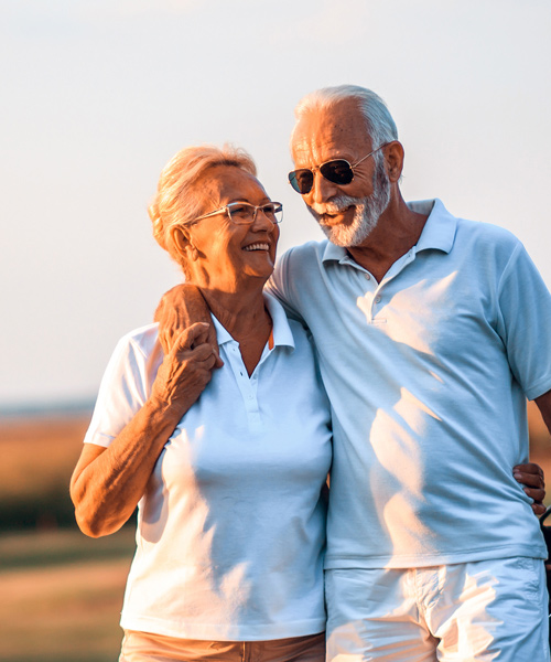 happy mature couple walking at sunset